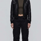 Front view lookbook photography of a model showcasing the Jackero premium black leather hooded Y2K bomber jacket styled with modern urban techwear.