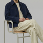 minimalist dark blue suede casual jacket a clean studio backdrop.