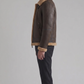 a heavy-duty dark brown leather aviator jacket showing panel stitching and structured shoulders.