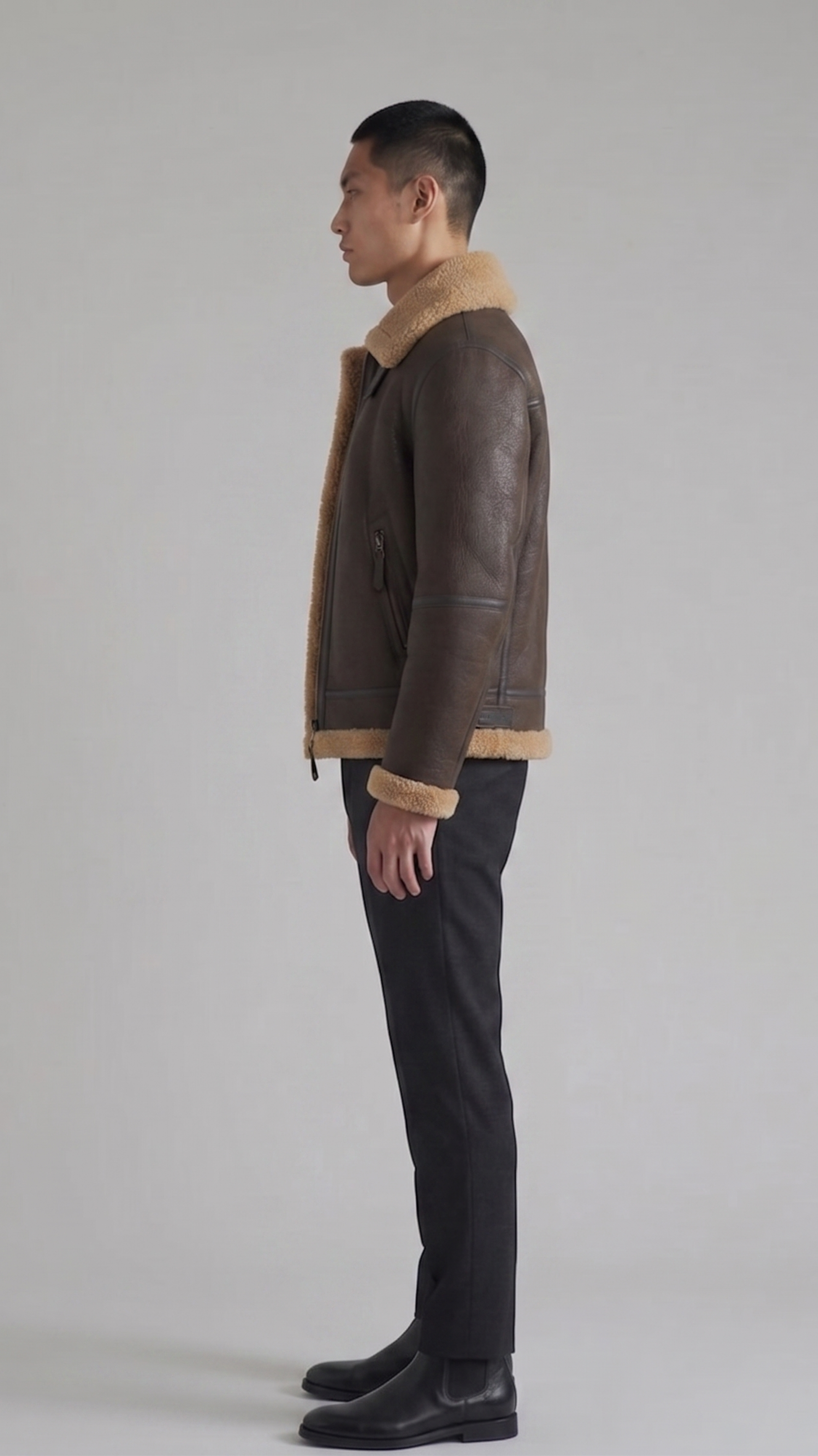 a heavy-duty dark brown leather aviator jacket showing panel stitching and structured shoulders.