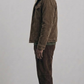 a model wearing a dark chocolate brown suede jacket with cream shearling trim.