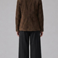 Model wearing a JACKERO chocolate brown suede shacket paired with a black top and wide-leg black trousers.