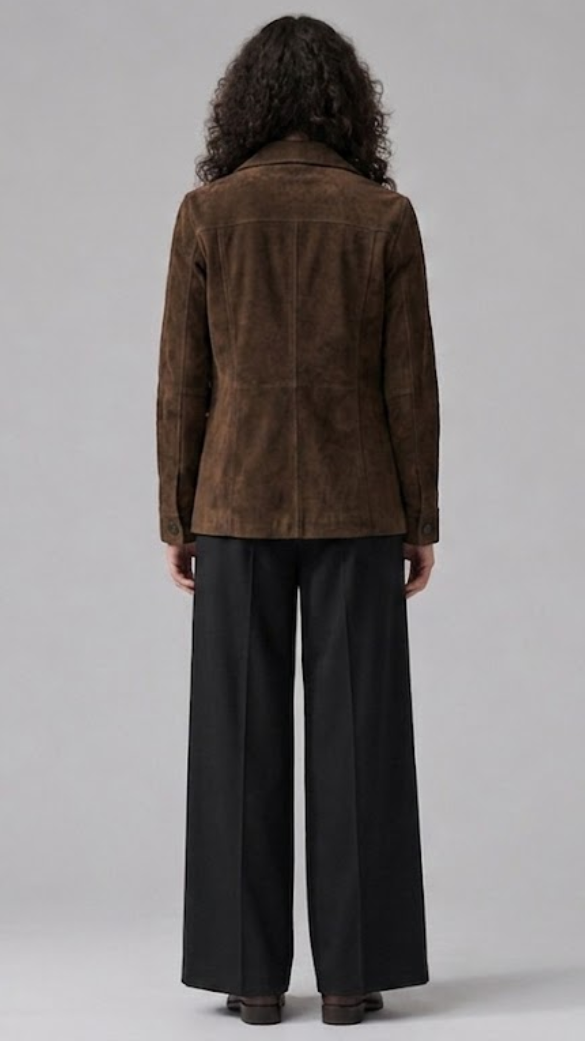 Model wearing a JACKERO chocolate brown suede shacket paired with a black top and wide-leg black trousers.