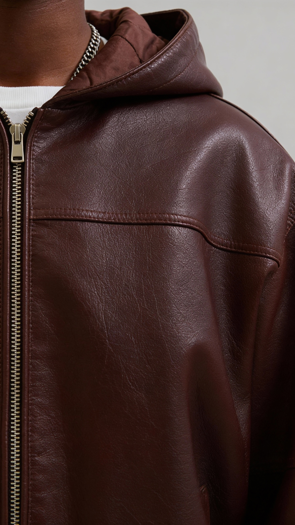 Close-up shot of the high-quality soft sheepskin leather on Jackero's dark maroon hooded bomber jacket, highlighting the luxury textured finish.