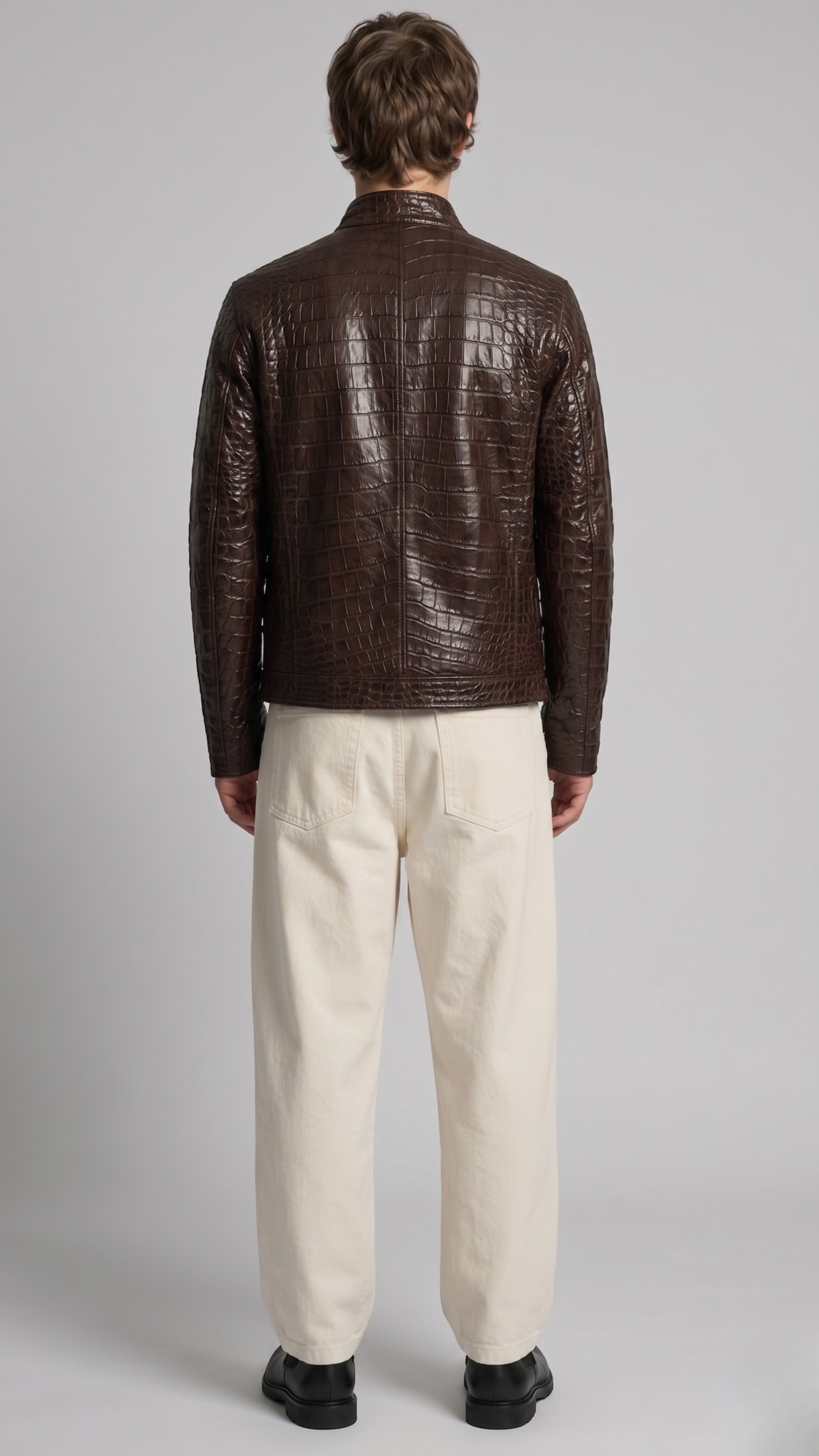 Back view of a custom dark brown leather jacket showcasing the continuous embossed crocodile texture and structured fit.