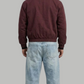 a minimalist deep maroon cotton jacket with simple cuffs.