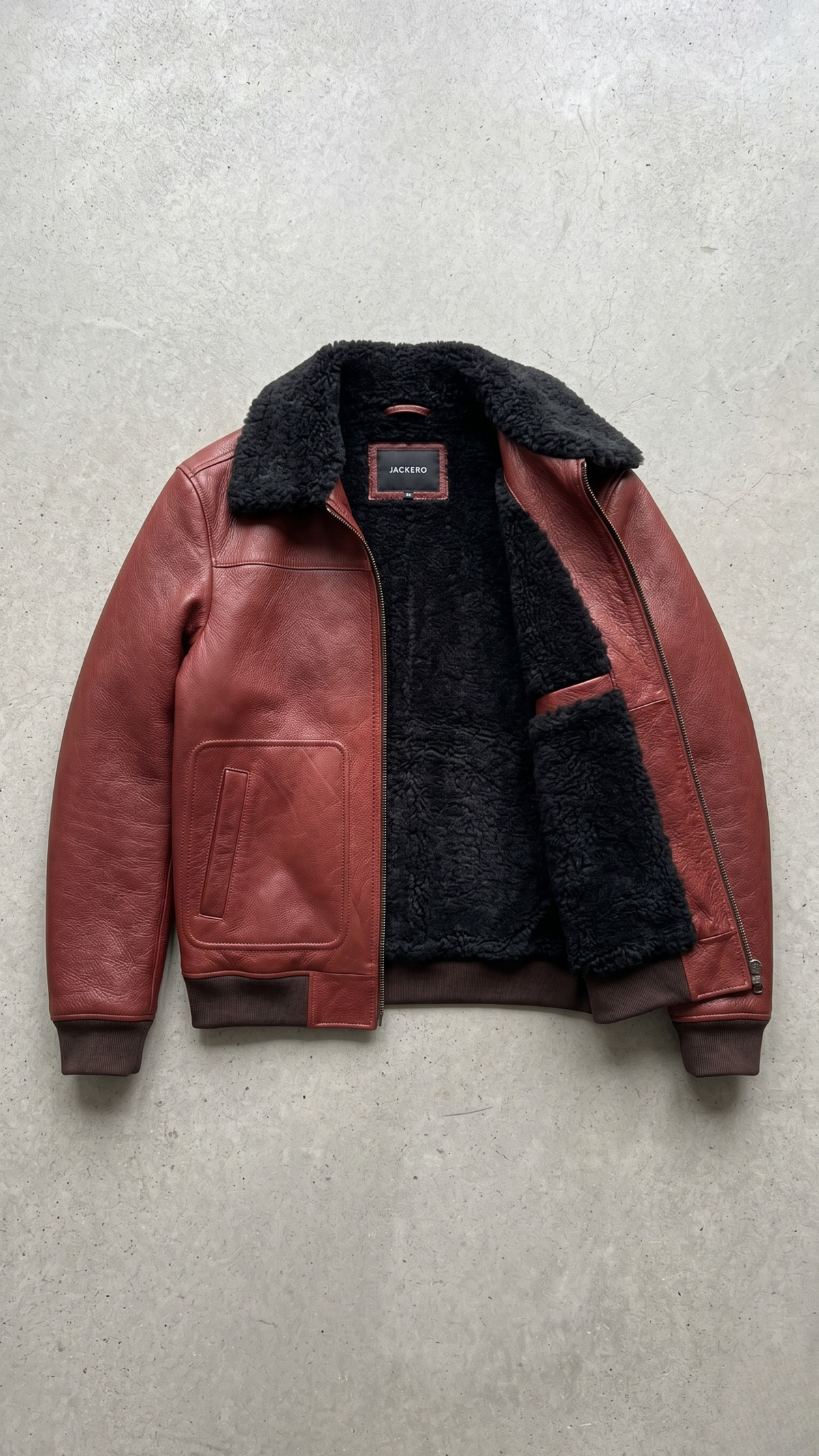 Flat lay setup featuring the premium cognac brown leather bomber jacket styled flat for online catalog merchandising.