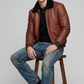 rich grain of the cognac tan leather contrasting against the dense plush black shearling lapel texture
