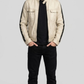 minimalist panel structure and pristine cream leather profile of the luxury racer coat.