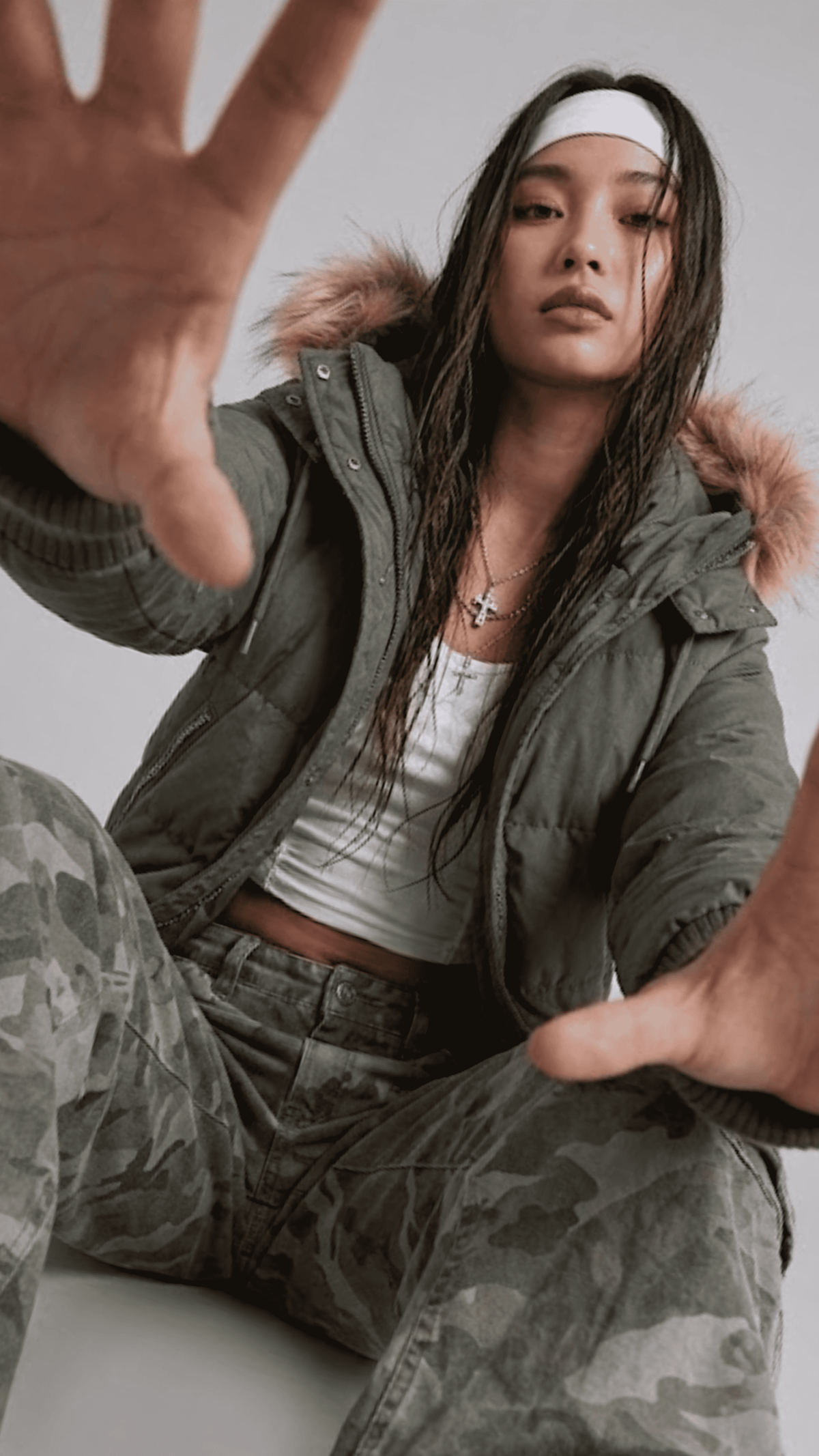 Detailed close-up shot of the plush faux fur trim and insulated hood on an olive green oversized winter jacket