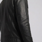 Close-up micro detail focusing on the premium smooth texture of black genuine leather contrasted with heavy-duty silver metallic zippers.