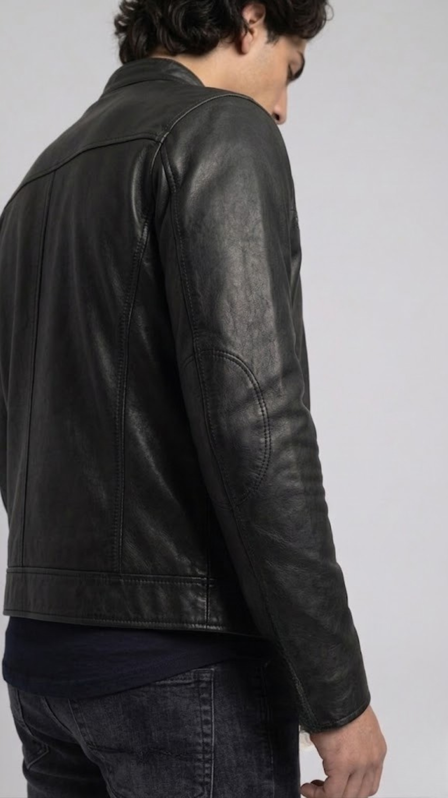Close-up micro detail focusing on the premium smooth texture of black genuine leather contrasted with heavy-duty silver metallic zippers.