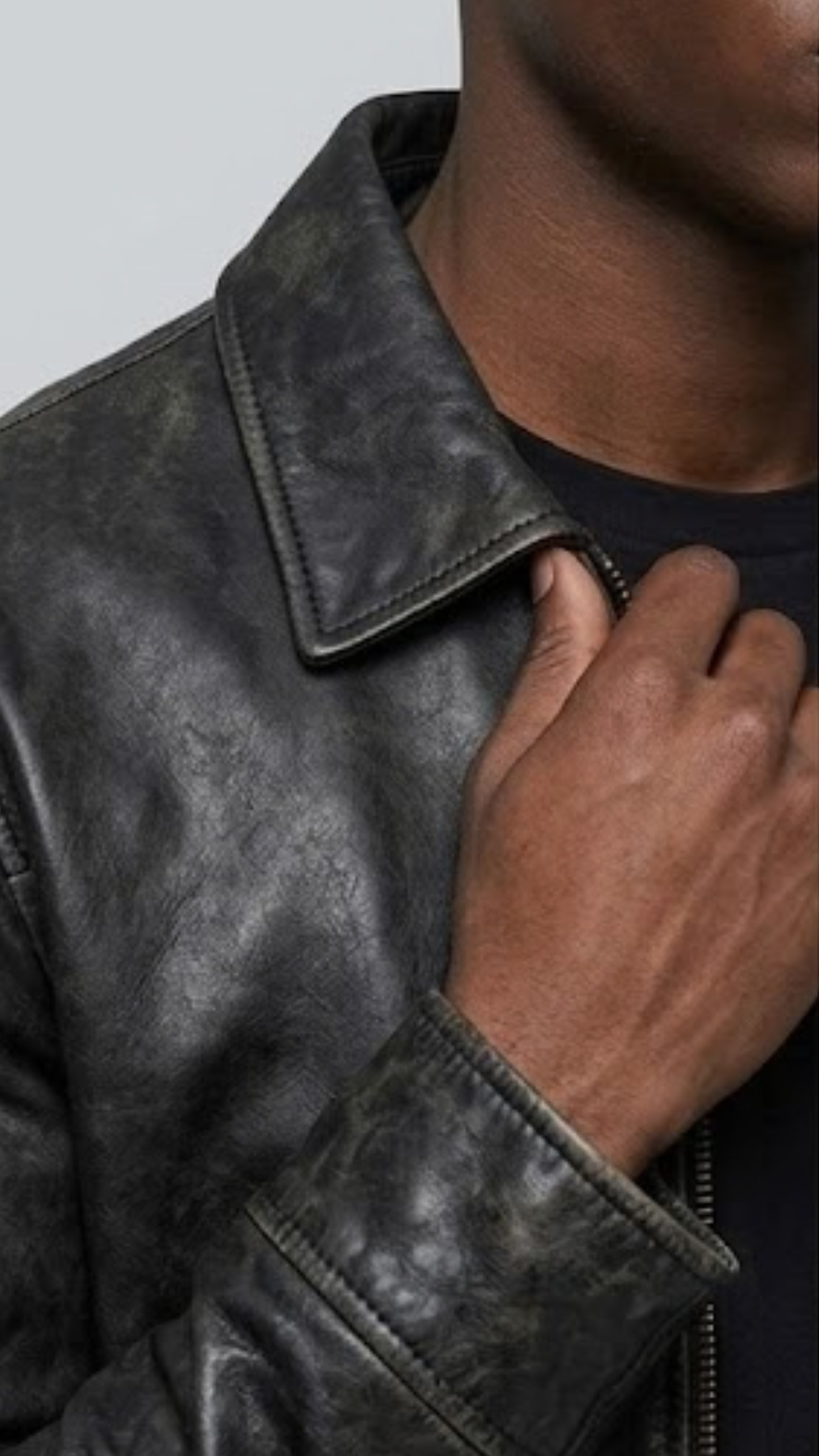 Close-up micro detail focusing on the premium, buttery-smooth texture of flawless black genuine leather and neat tonal stitching.