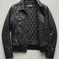Minimalist classic black leather bomber jacket displayed against a clean background for apparel catalog.