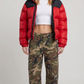 A model showcasing the Jackero red and black colorblock puffer jacket in a full streetwear look.