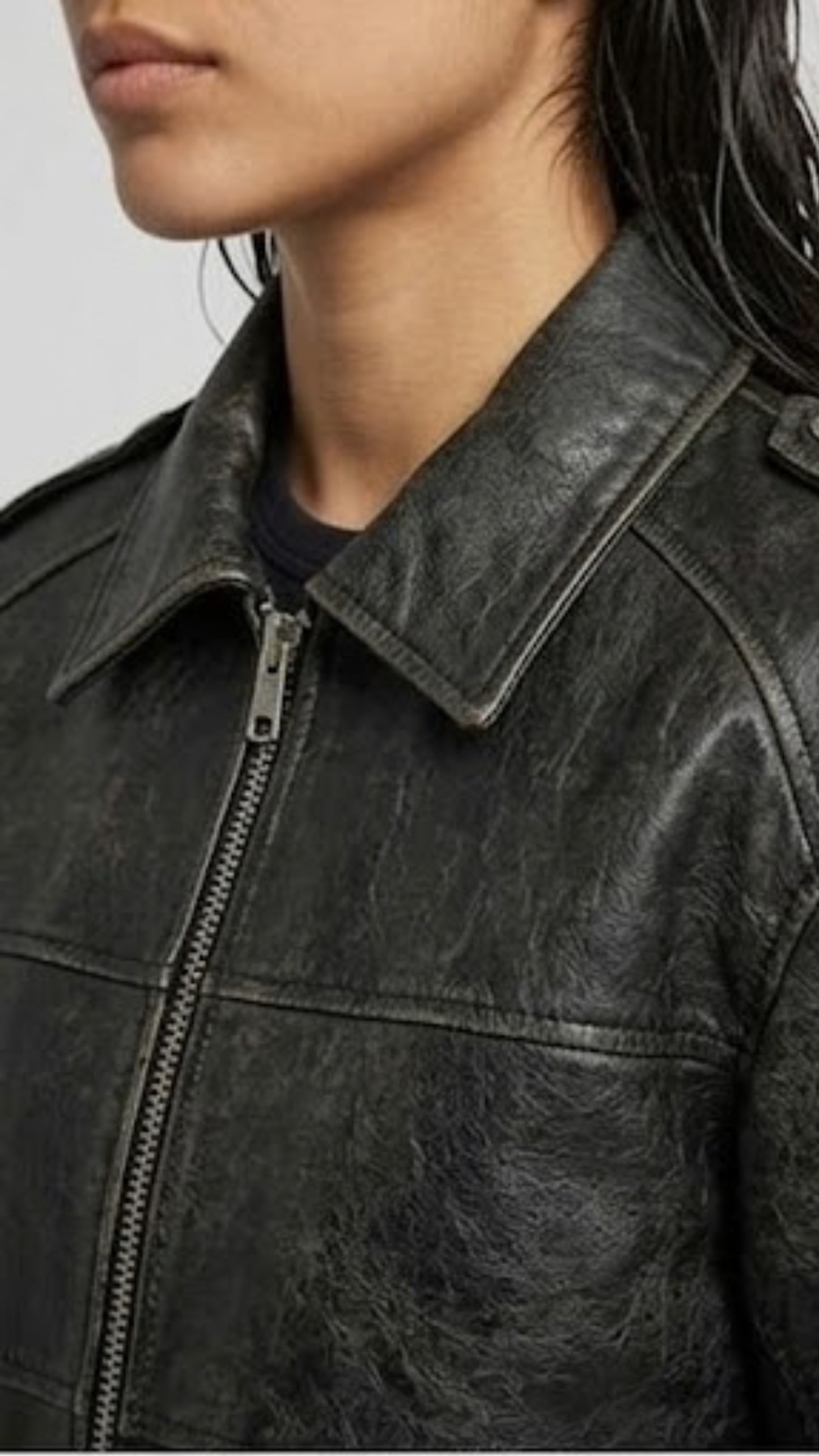 Close-up detail focusing on the subtle faded highlights of the vintage-wash black leather material and heavy-duty zipper hardware.