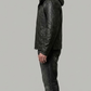 Man wearing a black leather jacket and jeans on a gray background