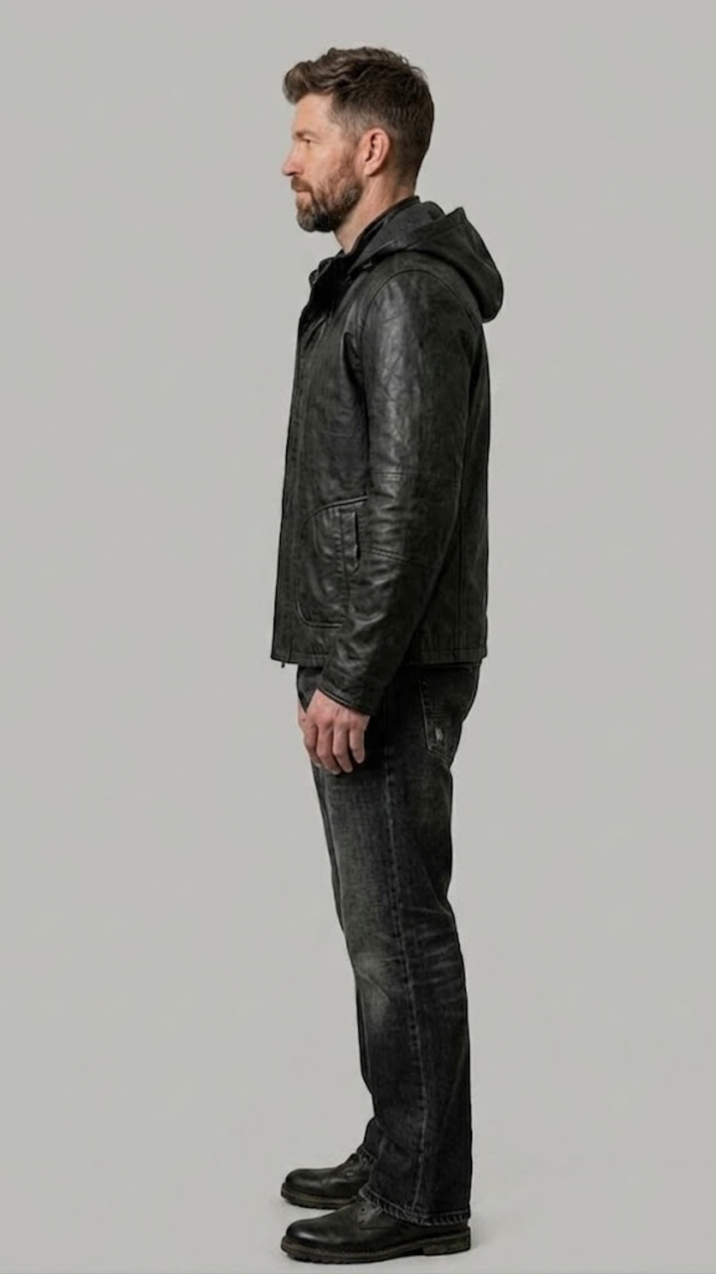 Man wearing a black leather jacket and jeans on a gray background