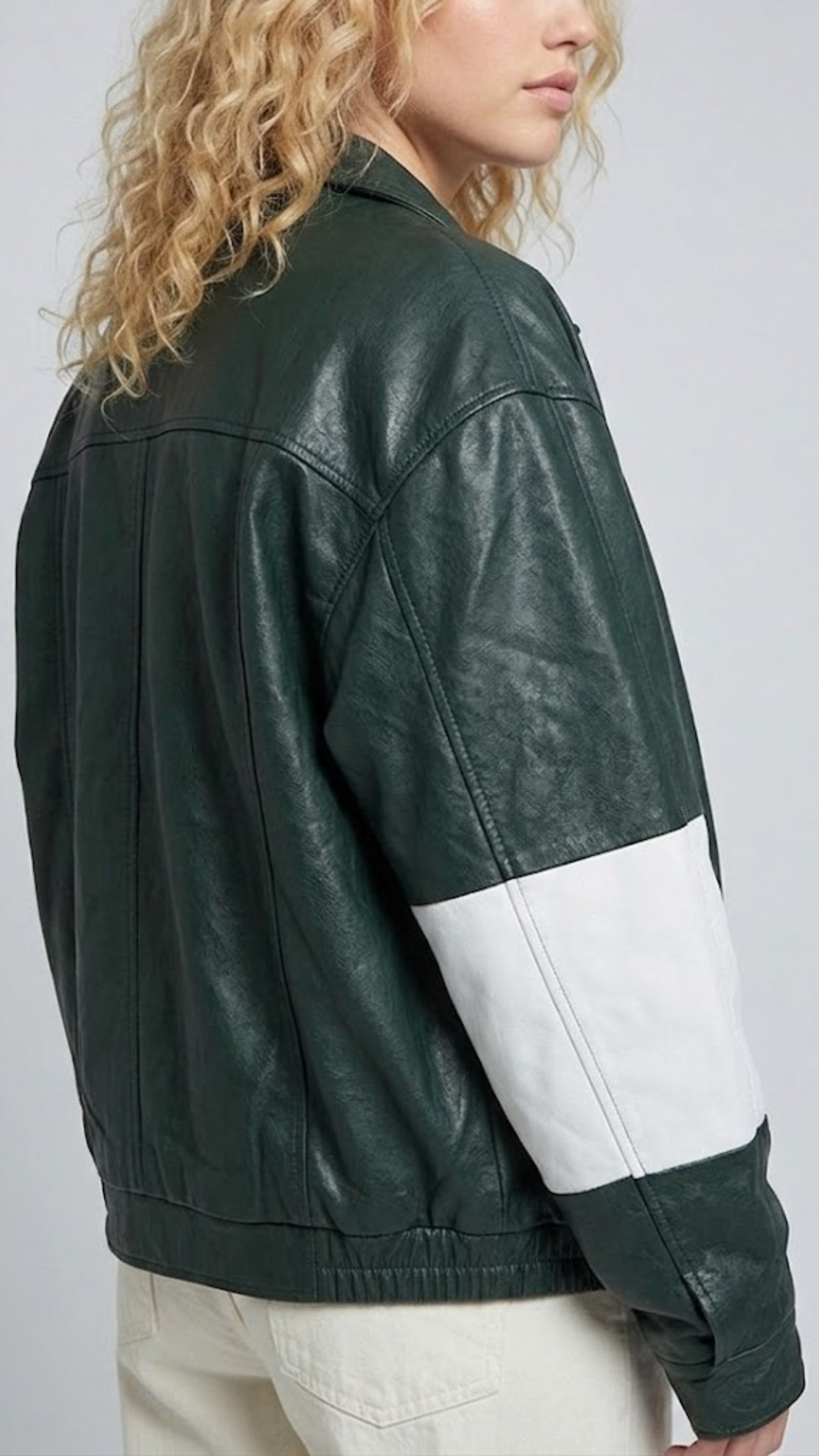 Close-up micro detail focusing on the premium dark green leather texture contrasted with the stitched white stripe accents and hardware.