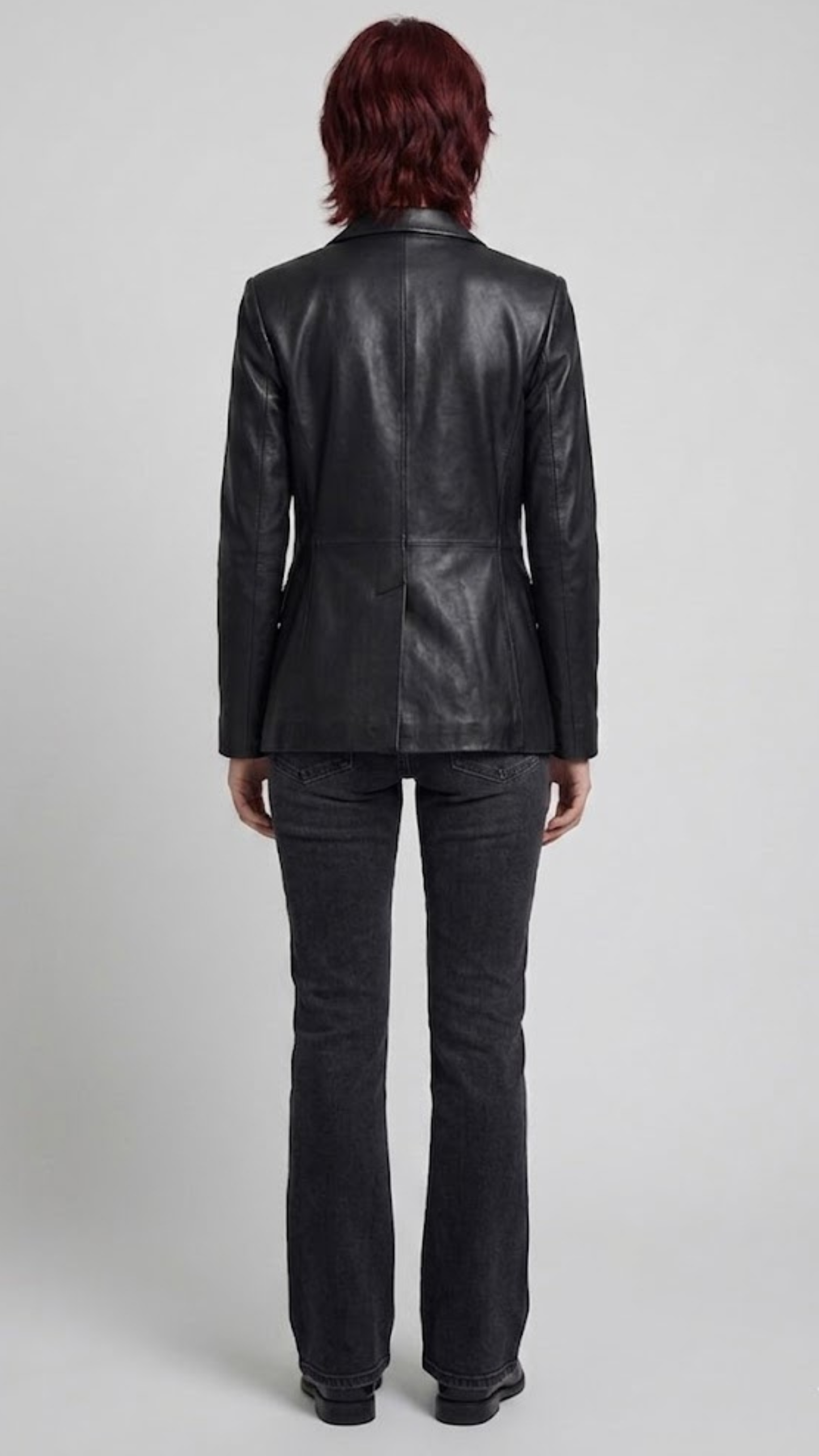 back-angle profile of a regular fit women's black leather dinner jacket displaying smooth drape and premium leather material quality.