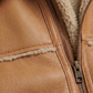 Close-up of a brown leather jacket with a zipper