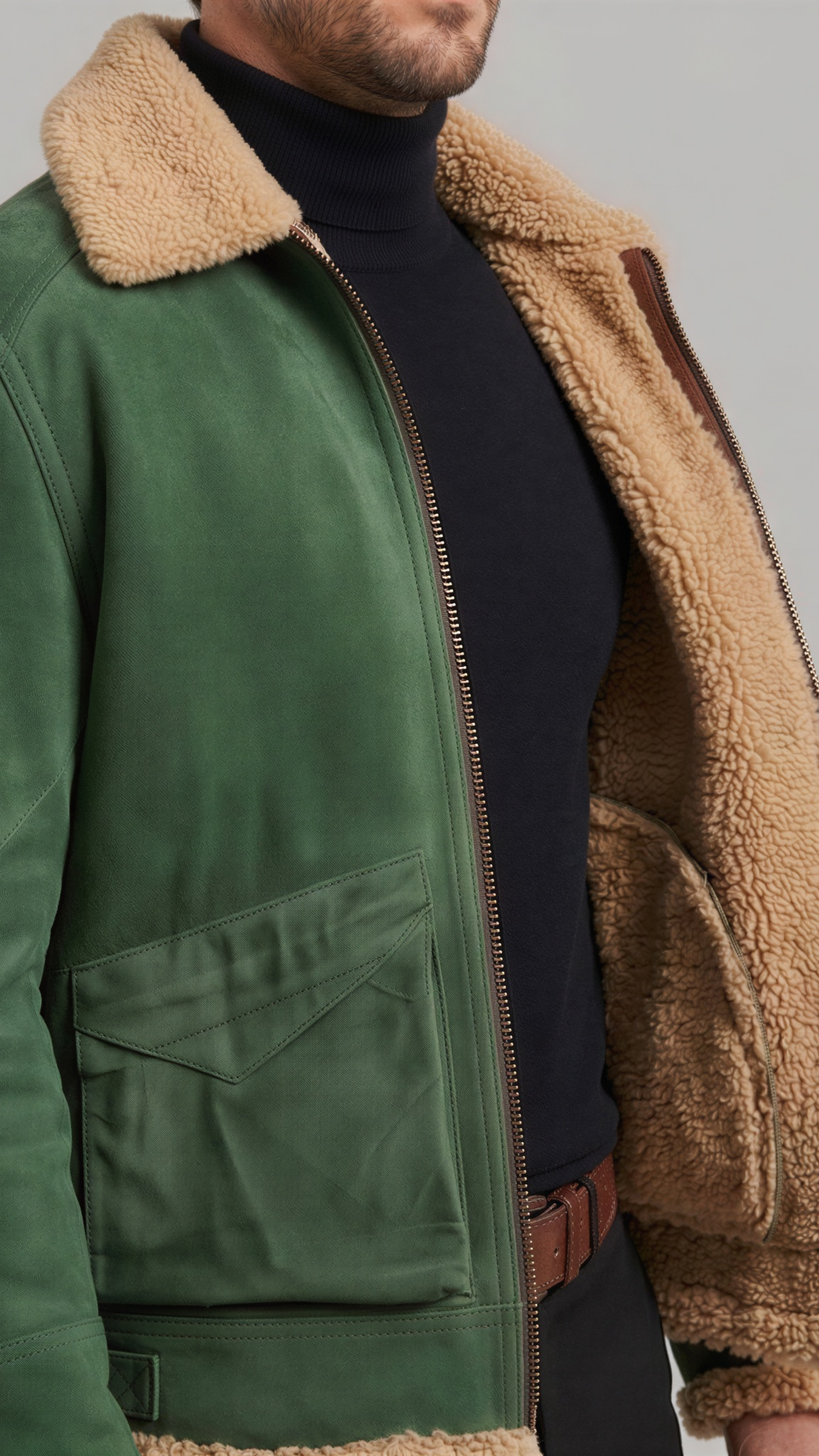 Green jacket with brown sherpa lining worn by a person on a neutral background