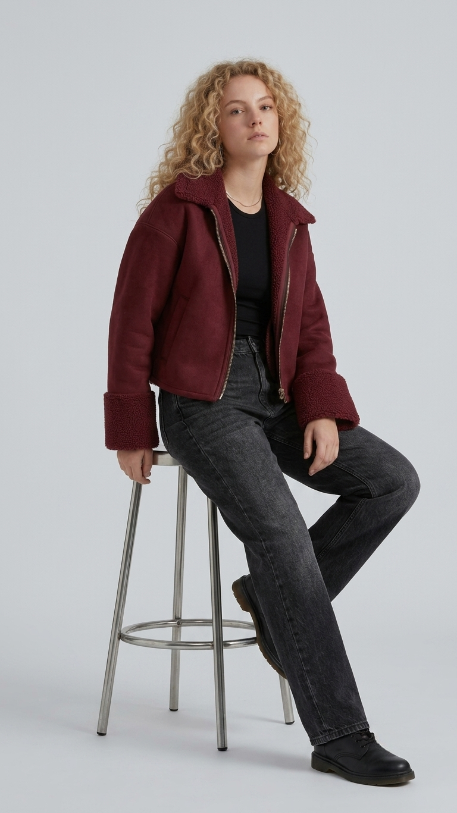 Streetwear fashion lifestyle photograph of a men's heavy winter look featuring a dark maroon suede aviator jacket with warm shearling lining.