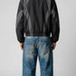 Rear view of loose fit black and dark grey nylon jacket showing colorblock paneling across the shoulders