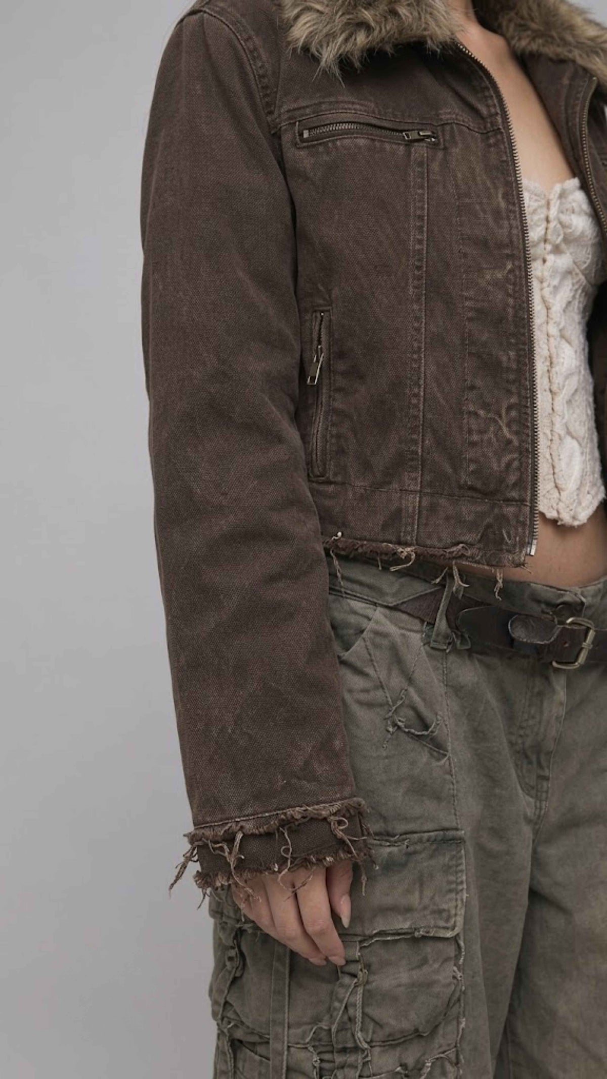 Close-up shot of the plush fur collar attached to dark khaki rugged denim fabric weave