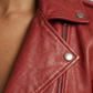 Close-up micro detail focusing on the premium texture of red genuine leather contrasted with heavy-duty silver metallic zippers.
