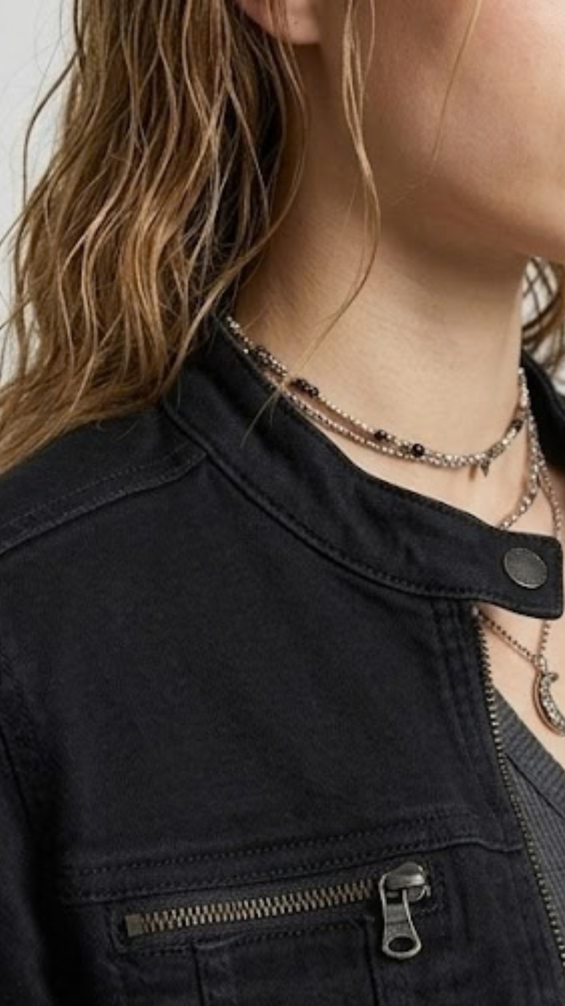 Close up shot of durable high quality black denim fabric weave and metallic button detailing