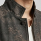 Close-up of a person wearing a textured charcoal distressed leather jacket with a neutral background
