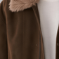 Brown coat with fur collar worn by a person, on a neutral background