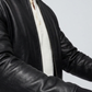 Macro detailed focus capture capturing the luxurious fine-grain texture and rich subtle sheen of the authentic black leather bomber fabric.