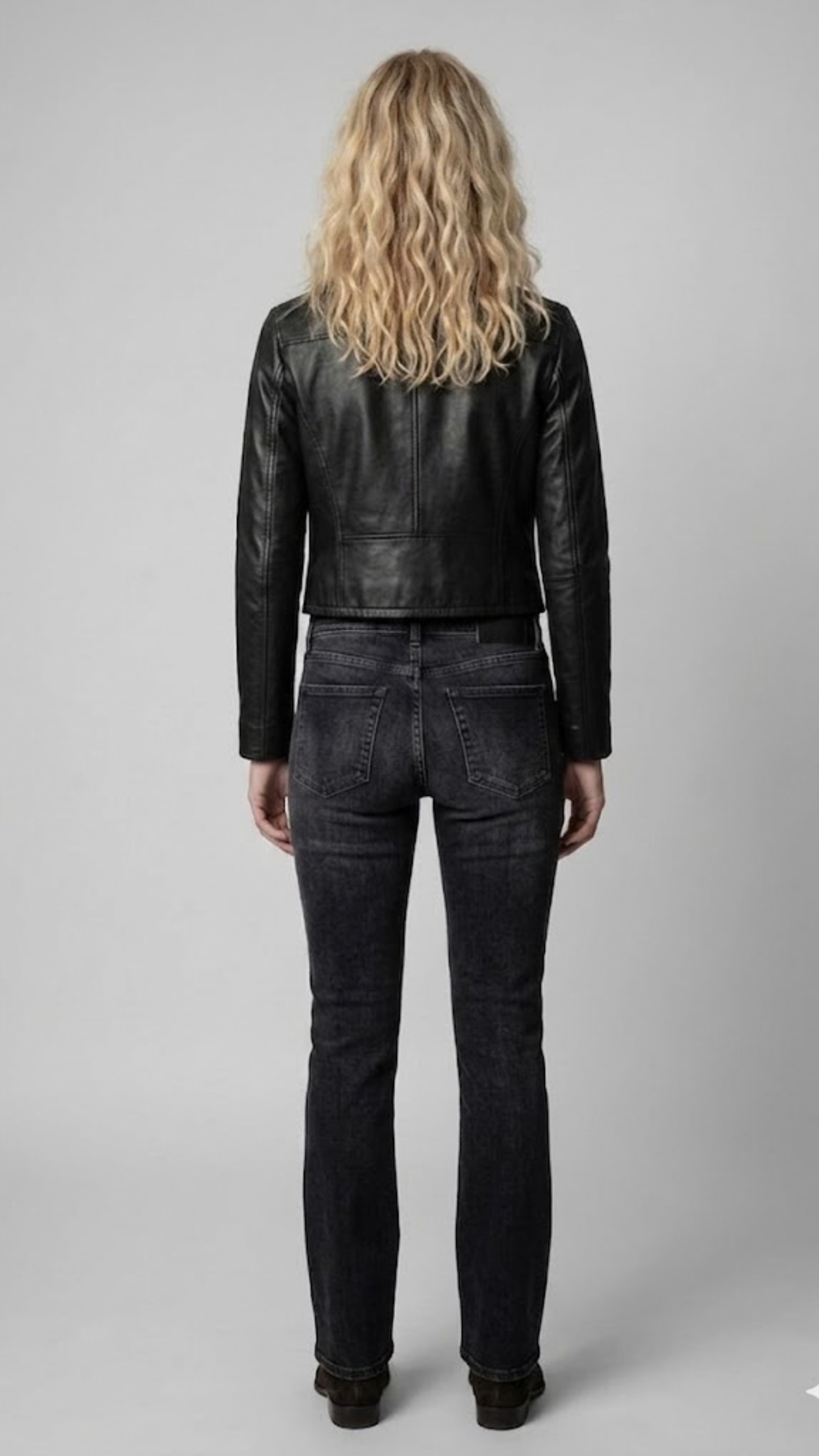 Model showcasing a fitted black genuine leather jacket for a timeless, sophisticated casual look.