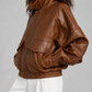 Smooth caramel-toned leather bomber jacket for women featuring a fold-down collar and zipper-closure front.