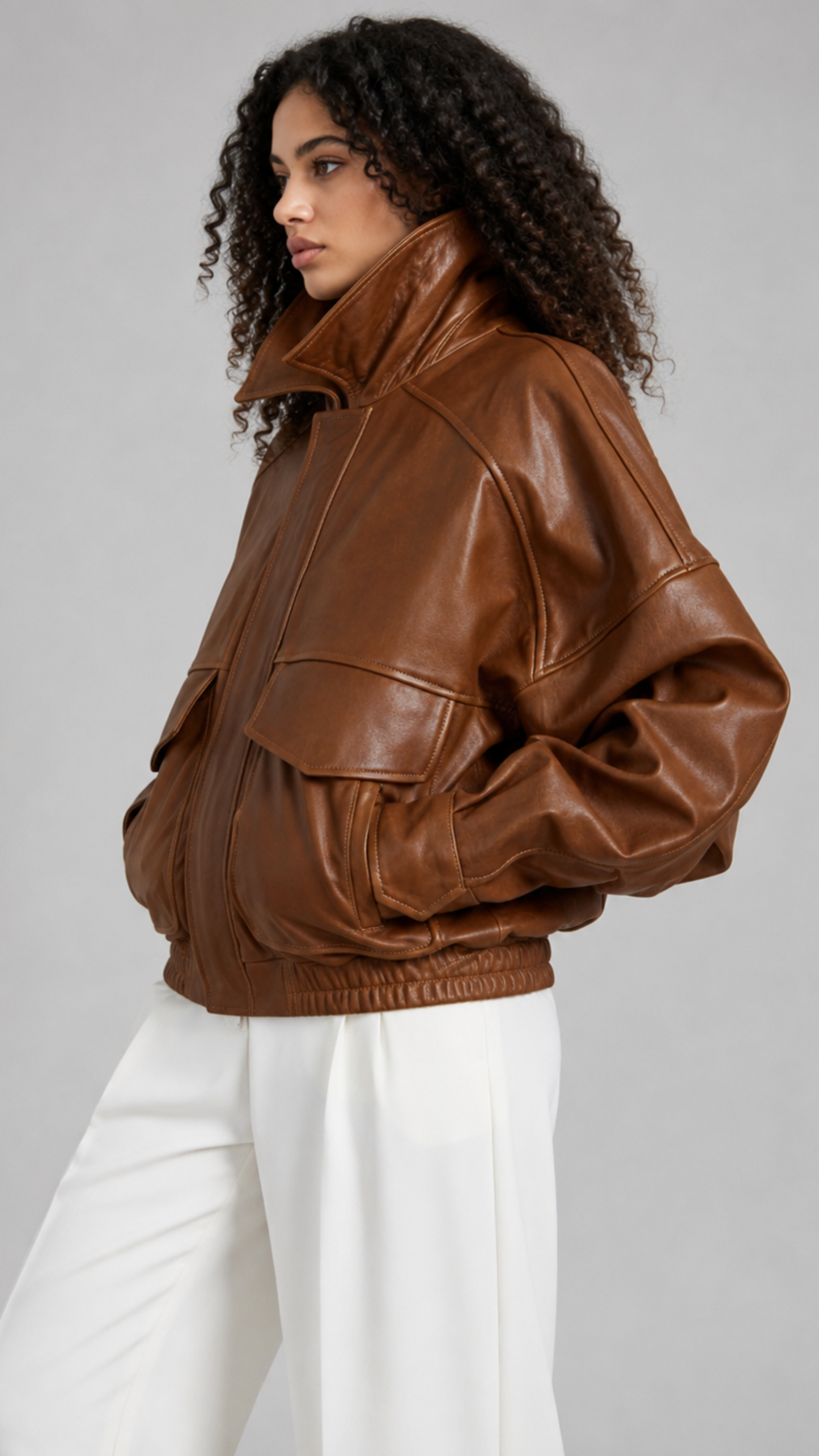 Smooth caramel-toned leather bomber jacket for women featuring a fold-down collar and zipper-closure front.