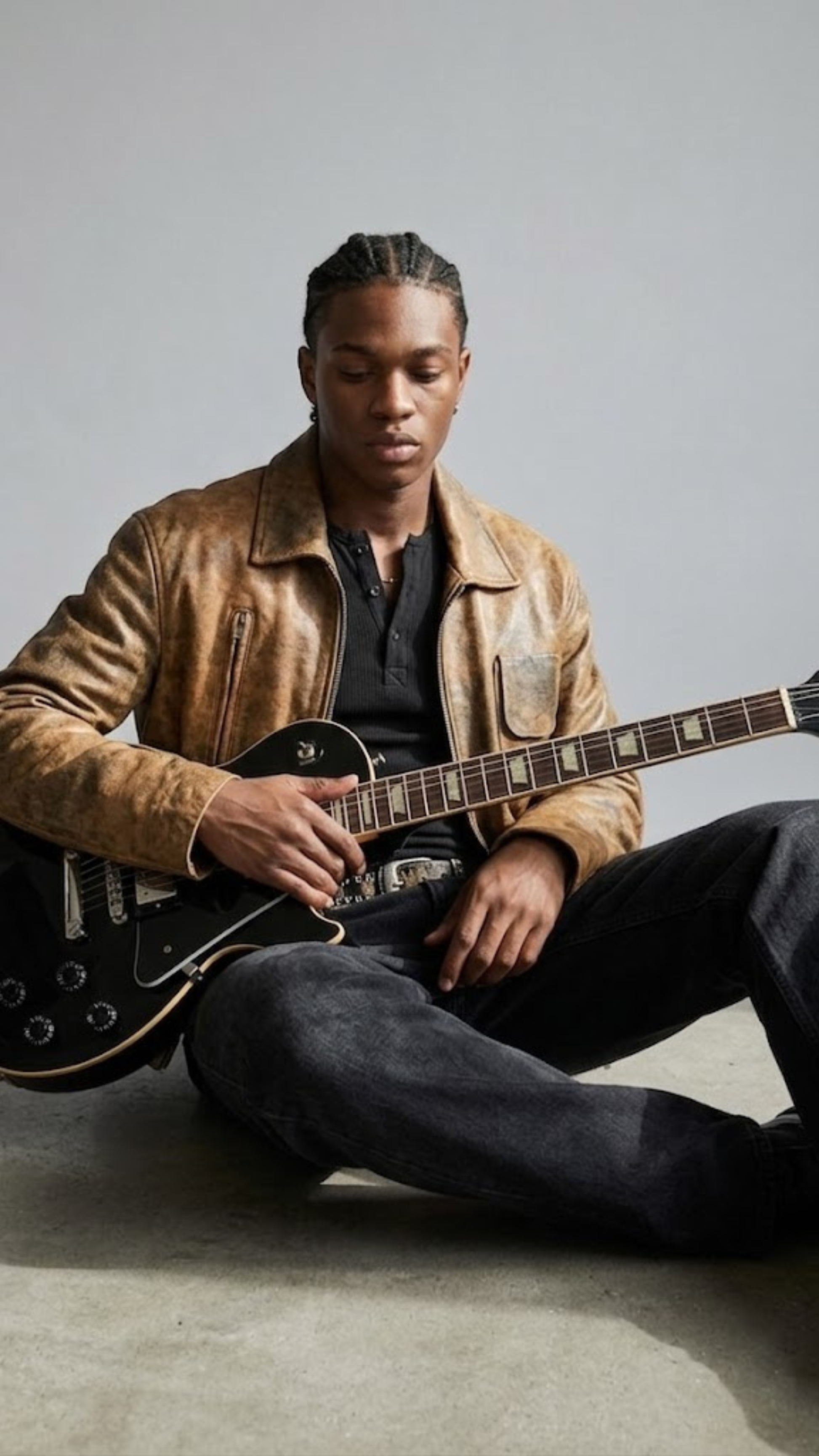 distressed light brown leather jacket sitting pose