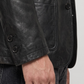 Close-up shot highlighting the seamless pocket stitching and premium button craftsmanship on a minimalist black leather suit jacket.