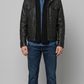 Full-body studio lookbook photo of the Jackero classic black leather trucker jacket with clean silver button accents, front pose orientation.