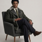 Professional studio showcasing a sophisticated dark grey long leather shearling coat.