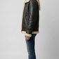 the rich texture of the soft faux cream fur lining against the premium black leather.