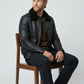 Rugged yet refined winter fashion lifestyle concept featuring an all-black leather bomber jacket with cozy fur collar detailing.