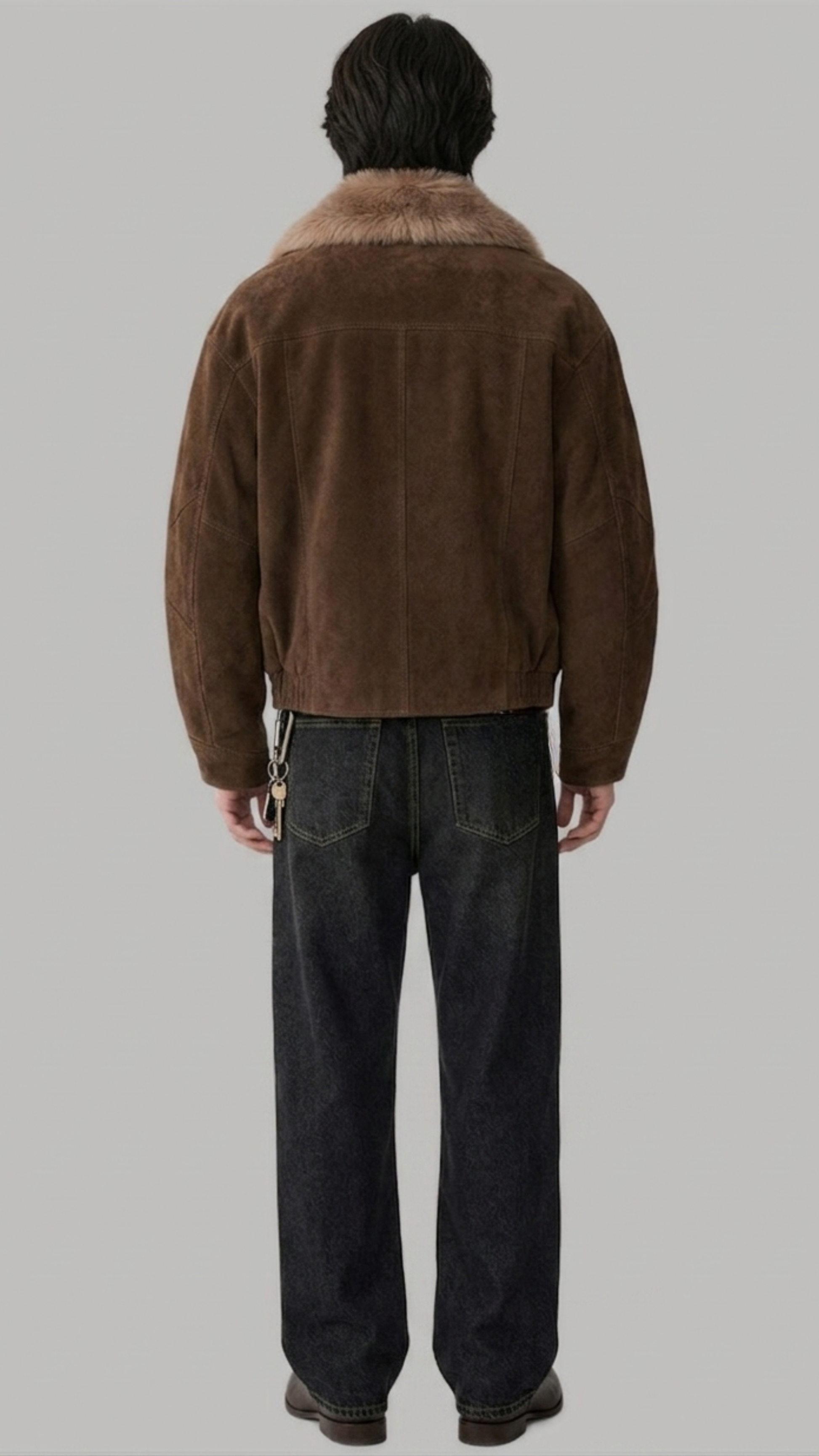 Rear view of a men's classic dark brown leather jacket with shearling lining, highlighting clean panel seams and a structured waistband.
