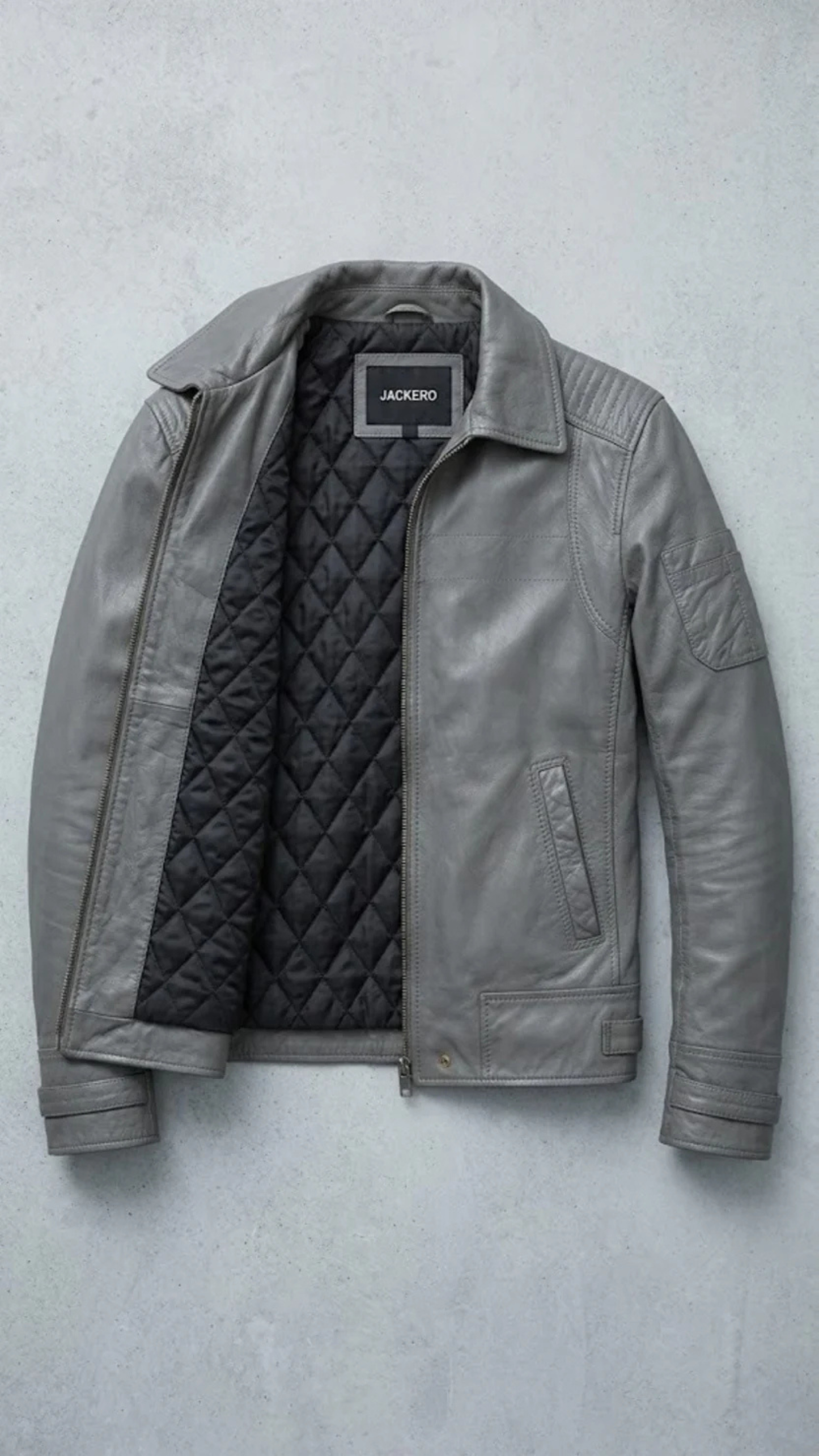 Gray leather jacket with quilted lining on a light gray background