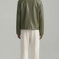 Men styling a premium sage green leather overshirt jacket over a neutral t-shirt, showcasing a clean minimalist streetwear look.
