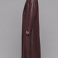Side angle of model wearing jackero dark red vine leather trench coat showing full flowy silhouette and sleeve cuff construction