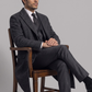 Men's sophisticated winter fashion showcasing a tailored dark grey wool overcoat styled for a sharp, professional look.