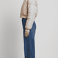 Detailed view of the structured neat collar stitching and precise finished hemline on a premium light beige cropped fashion jacket.