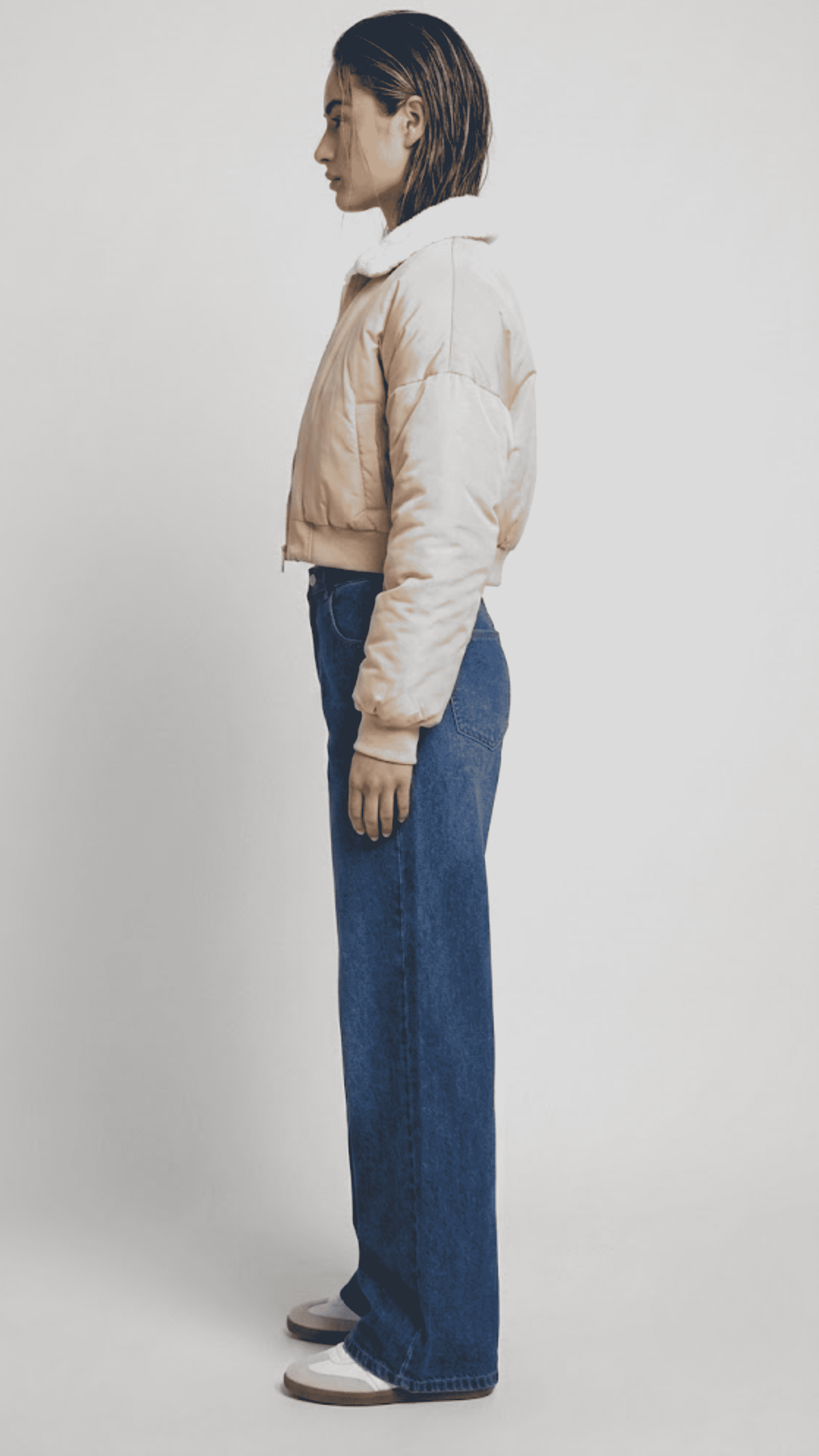 Detailed view of the structured neat collar stitching and precise finished hemline on a premium light beige cropped fashion jacket.